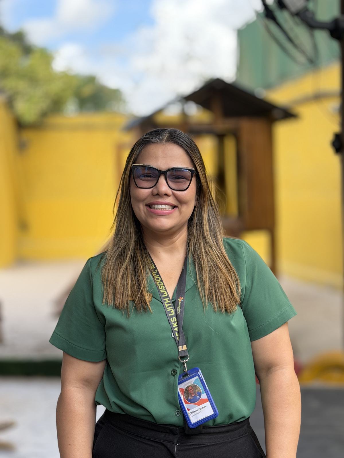 Coordenadora da escola, sorrindo, no pátio
